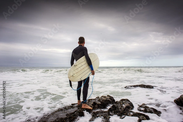 Fototapeta Surfer on Rocks Viewing Surf