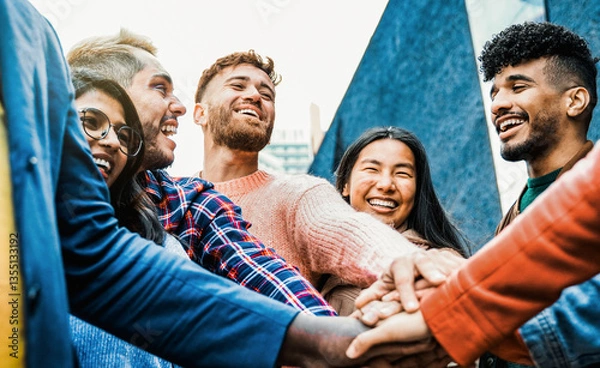 Fototapeta Group of people stacking hands, celebrating together. Diverse friends having fun supporting each other