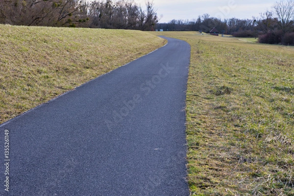 Fototapeta asphaltierter Ragweg an einem Damm
