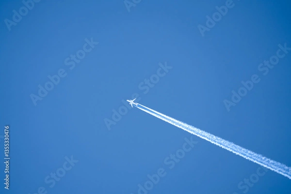 Fototapeta a twin engined jet liner aircraft in deep blue sky, contrails vapour trails