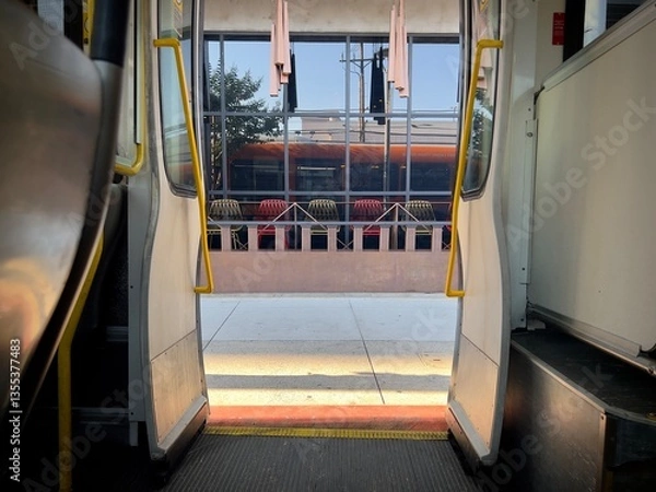 Fototapeta Interior view from inside a metro bus, looking out at sidewalk with colorful seats and morning light