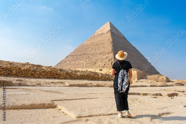 Fototapeta Back view of woman looking at Great Pyramids of Chephren and Cheops, Cairo, Egypt. Two of the three Great Pyramids, Giza pyramid complex (Giza Necropolis)