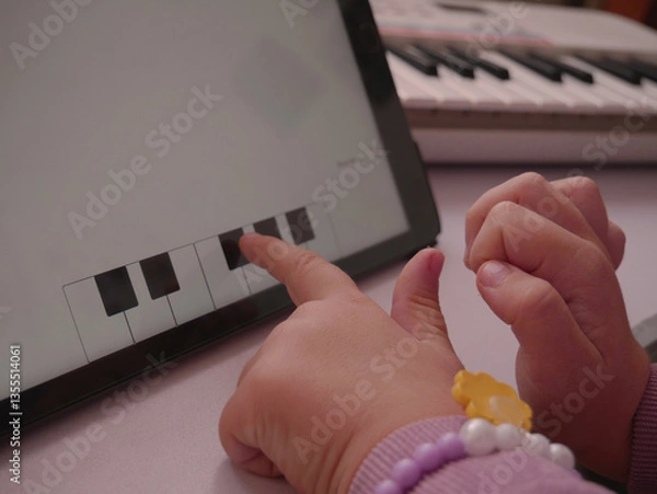 Obraz Music lessons app for children. Girl choosing the answer on screen.
