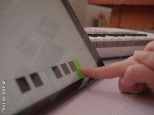 Obraz Child choosing correct answer on tablet music app hands close-up.