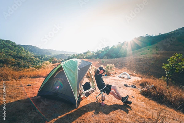 Fototapeta wanderlust and relax in nature with hiker man camping on top of mountain on spring and summer season