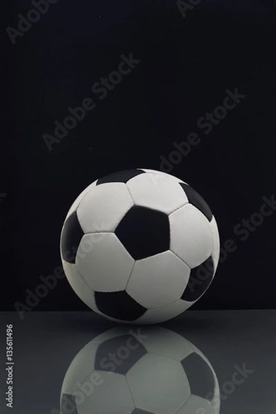 Fototapeta soccer ball with reflection on the table on a dark background