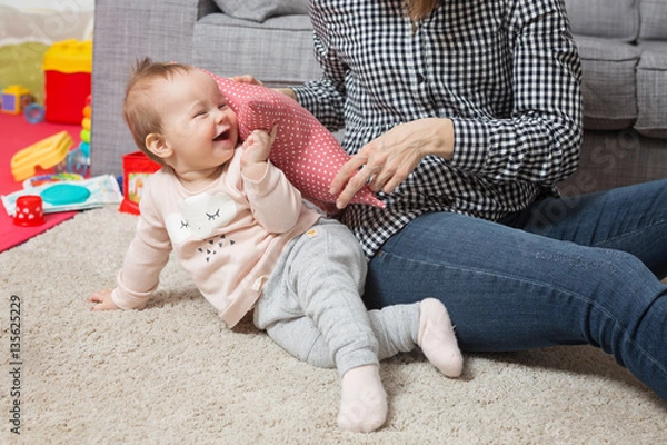 Obraz Nine months old baby girl playing with her mother on the floor