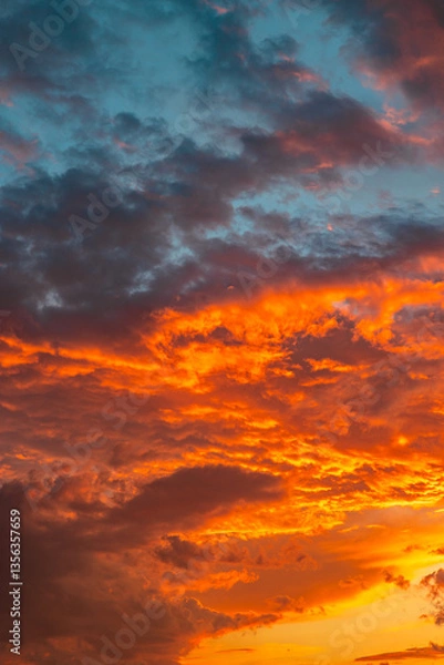 Fototapeta Orange clouds at sunset. Dramatic clouds background vertical photo