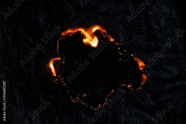 Fototapeta burning paper, glowing edge of paper on a black background
