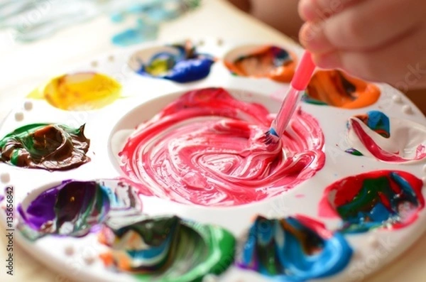 Obraz Child mixing paint on a palette of colorful paint