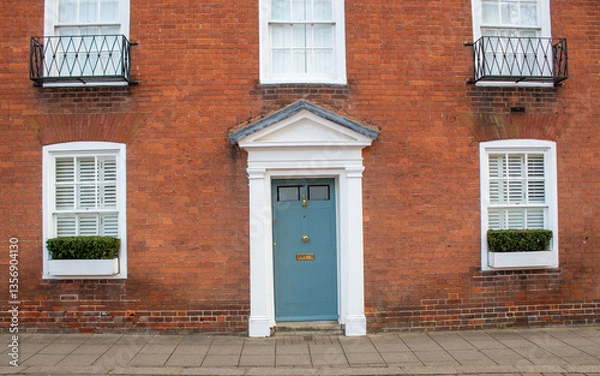 Obraz blue door with windows in brown building in England