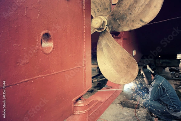Fototapeta Spawacz pracujący w stoczni, odcienie kolorów.