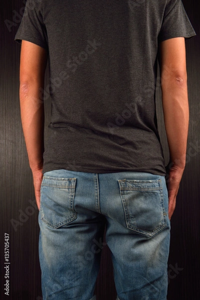 Obraz Back of young man wearing grey blank t-shirt, standing in a stud