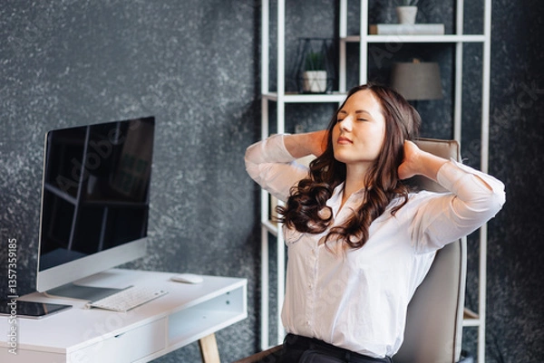 Fototapeta Businesswoman stretching in office chair during work break for relaxation