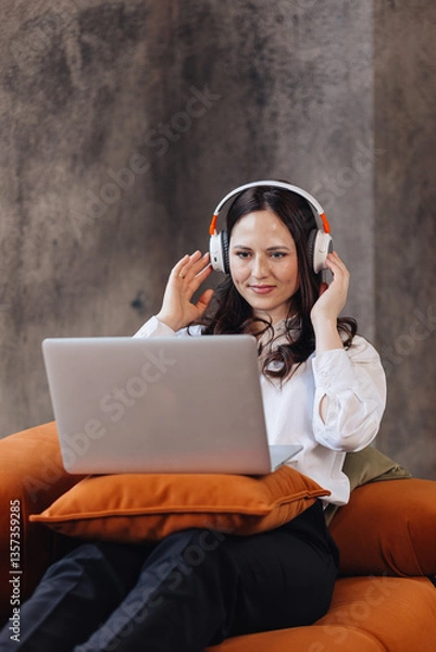Fototapeta Focused Businesswoman in Headphones Working on Laptop from Home Office