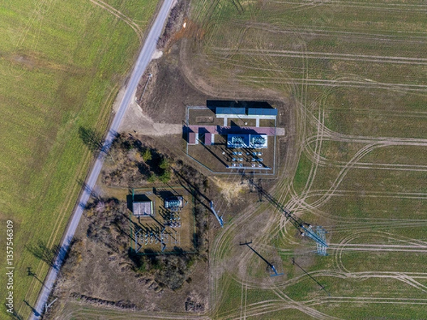 Fototapeta defaultAerial view of a substation captured from a 90-degree top-down shot, showcasing the layout of electrical transformers, power lines, and the surrounding infrastructure.