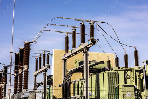 Fototapeta A close-up shot of a substation showing power lines, transformers, and electrical cables, highlighting the complexity of the energy infrastructure.
