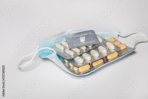 Fototapeta Protective medical mask on which lie the plates of various tablets.