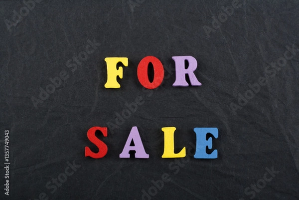Fototapeta For sale word on black board background composed from colorful abc alphabet block wooden letters, copy space for ad text. Learning english concept.