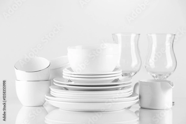 Fototapeta Different clean dishware and glasses on light background