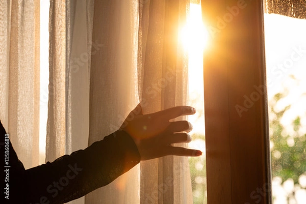 Obraz woman's hand She opened the curtains on the window. There was morning light through the window in her room, looking at the view of the mountains and trees as the sun rose.
