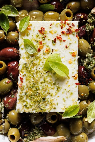 Fototapeta Close up view of feta cheese with mixed olives, olive oil and aromatic herbs 