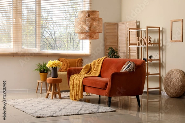 Fototapeta Comfortable sofa with plaid and  beautiful daffodils in living room