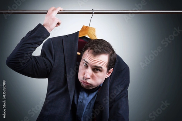 Fototapeta Man in suit hanging in the wardrobe. Embarrassing situation concept


