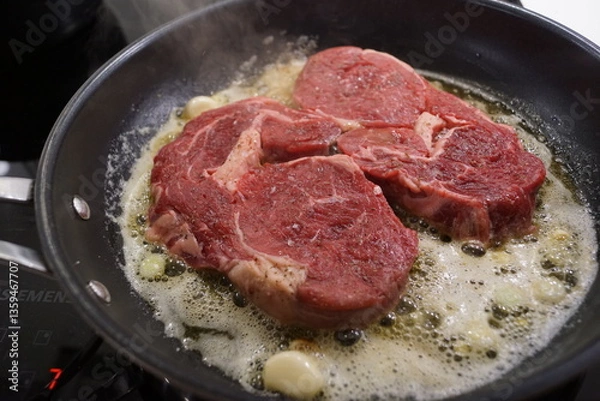 Obraz A large red beef steak being cooked to rare perfection on a searing pan