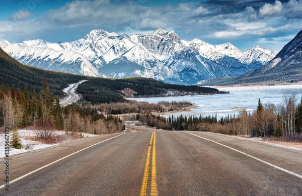 Fototapeta Scenery of Road trip on highway with rocky mountains and frozen lake at Icefields Parkway