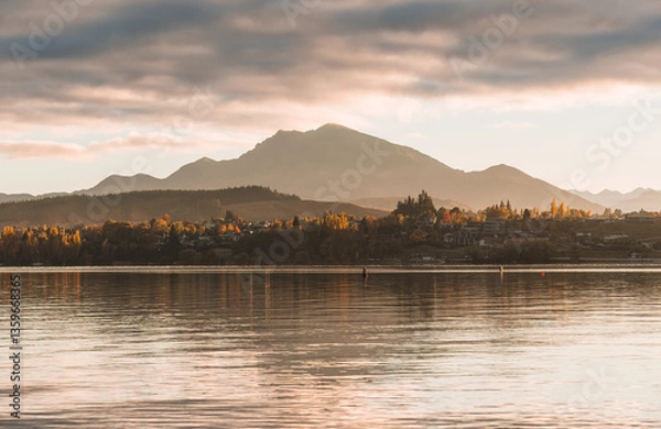 Fototapeta Scenery of sunrise over mountain range and autumn forest on Lake Wanaka