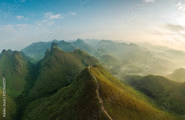 Fototapeta Scenery of Ba Guang grass hill, Mountain range with fog and villager bringing horse to graze on the mountain in the morning