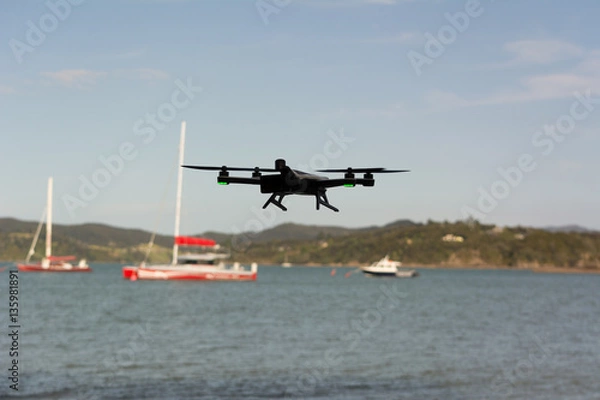 Fototapeta Drone flying with sailing boat in background