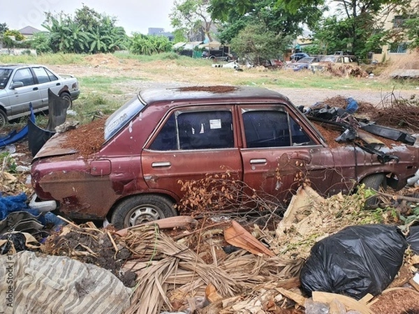 Fototapeta Old car wrecks are left to be washed on a lawn in Bangkok, Thailand, on March 7, 2025.