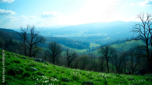 Fototapeta Serene Spring Meadow Hillside with Distant Blue Mountains and Bare Trees