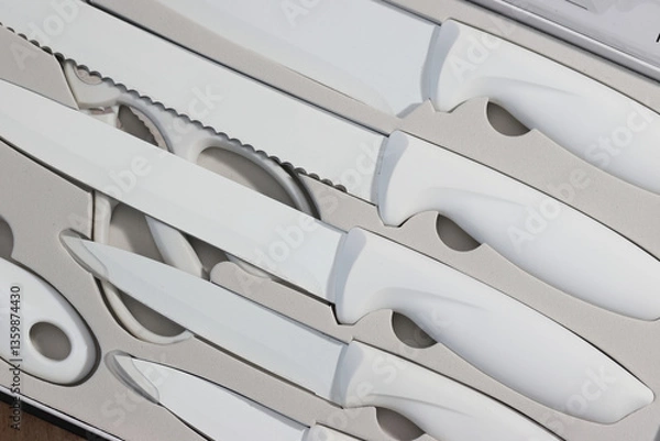 Fototapeta Gift set of kitchen knives. Knives of different sizes. White-coloфaфred knives in a gift box. High-Angle Shot.