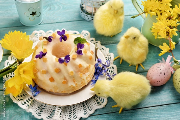 Obraz Traditional Easter ring cake with frosting and orange peels on blue wooden table