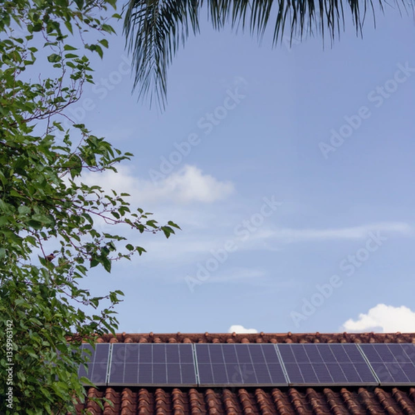Fototapeta Solar panels on the red roof in a sunny and cloudy day. Photovoltaic instalation image.
