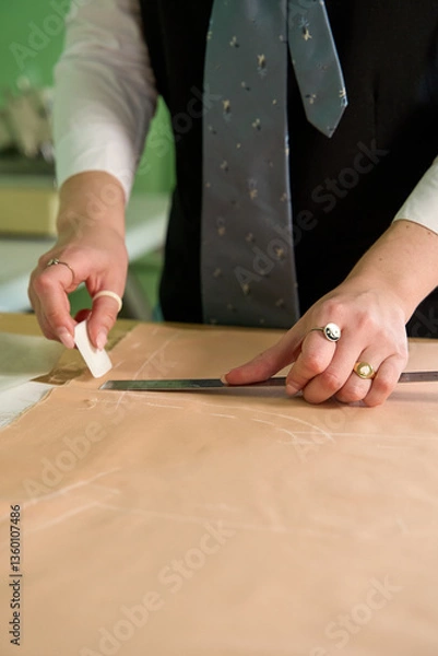 Obraz Dressmaker cutting dress fabric on sketch line with sewing machine. Fashion designer tailor or sewer in workshop studio designing new collection clothes. Business owner shop and entrepreneur concept