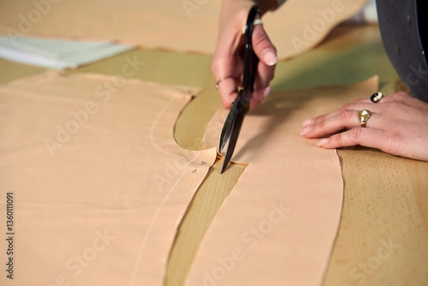 Obraz Dressmaker cutting dress fabric on sketch line with sewing machine. Fashion designer tailor or sewer in workshop studio designing new collection clothes. Business owner