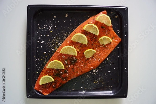 Fototapeta A whole red salmon filet with lemon and herbs