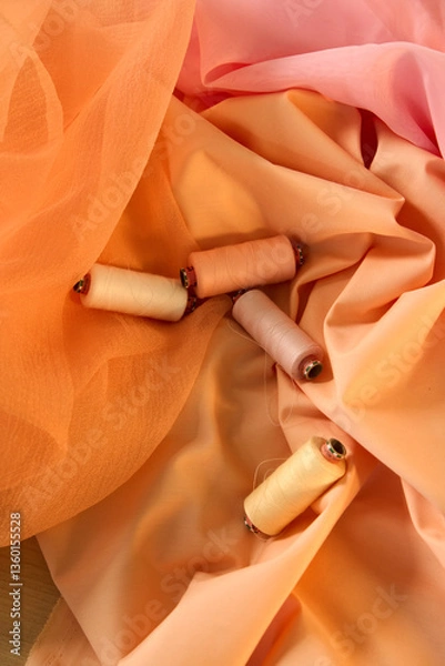 Obraz Spools of thread peach and yellow color on a peach and pink background