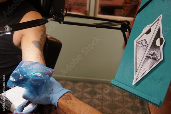 Obraz A man getting tattood at a modern classic tattoo parlor studio