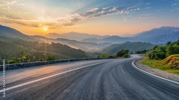 Fototapeta A winding road with a beautiful mountain range in the background.