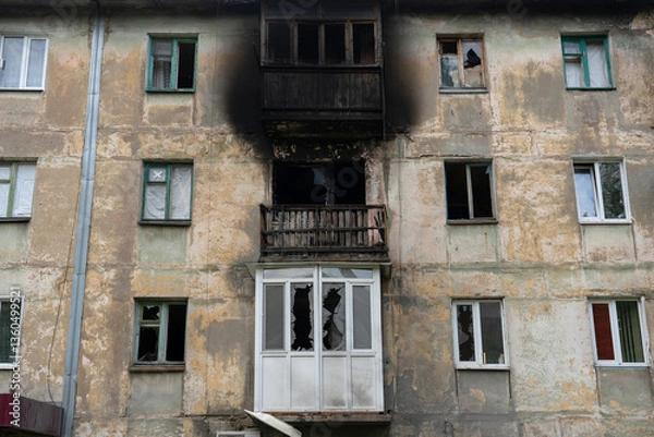 Fototapeta Apartment destroyed by explosion. Burnt facade. Broken windows in neighboring windows