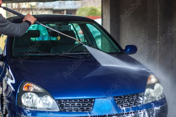 Fototapeta Car Wash Closeup. Washing Car by High Pressure Water