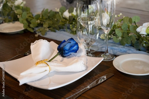 Fototapeta Decorations for the wedding receptions party have a single blue rose on each table setting for the guests