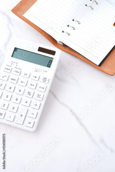 Fototapeta 電卓と手帳でデスクワークをしているイメージ
