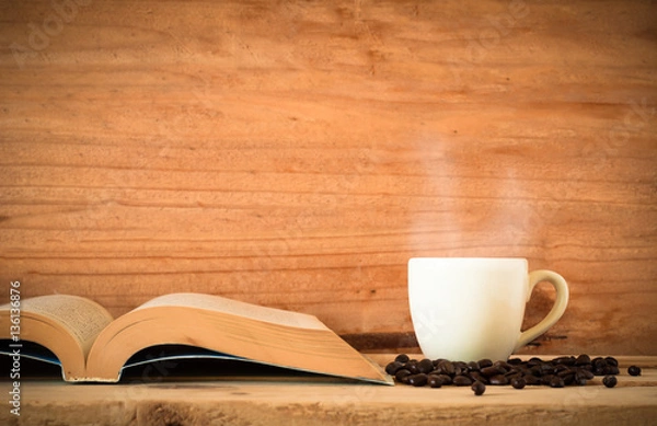 Obraz the book and hot coffee in white cup with black coffee bean on wood table