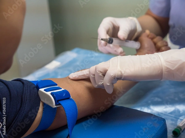 Fototapeta nurse with syringe is taking blood for test at the laboratory
